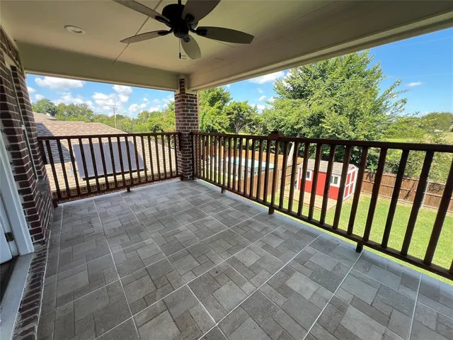 a view of a balcony with a ceiling fan and a window
