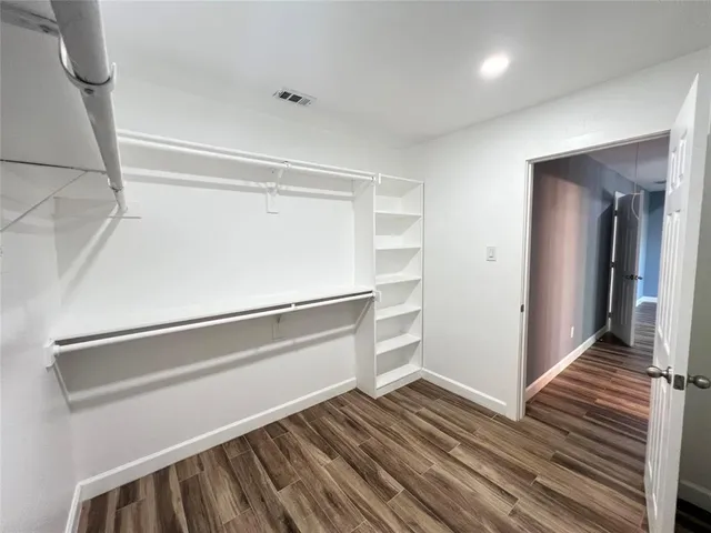 a view of walk in closet with empty racks