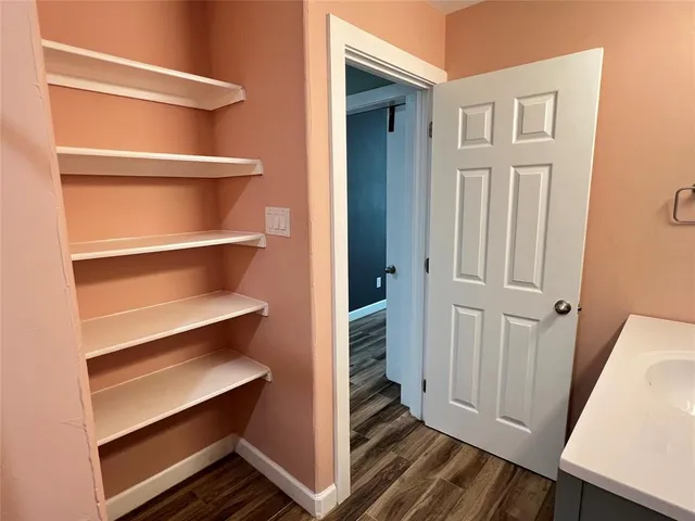 a view of empty room with wooden floor