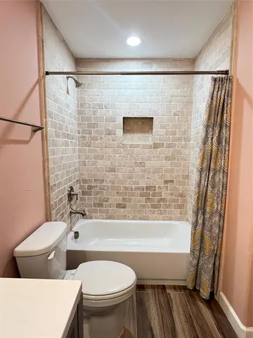 a view of a room with wooden floor and a ceiling fan