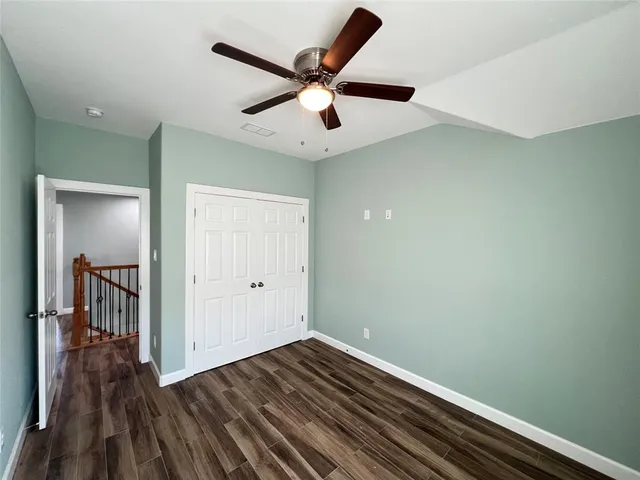 a view of a hallway with wooden floor and stairs