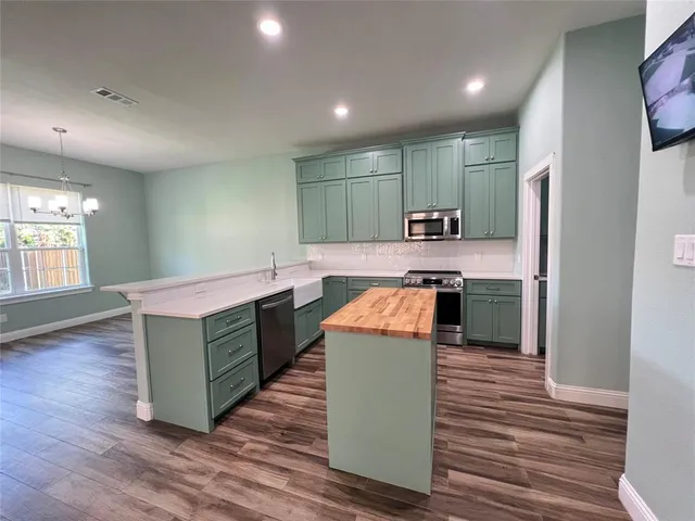 a kitchen with kitchen island a sink stainless steel appliances and counter space