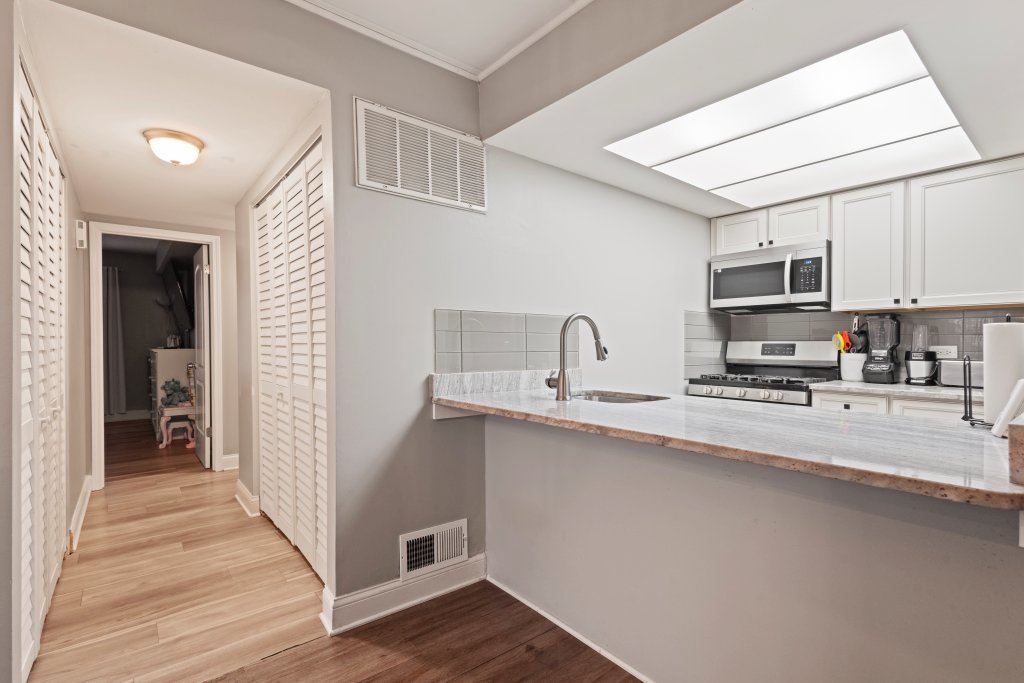 9830 Sayre Avenue, Unit 6 Chicago Ridge, IL 60415 - Photo 12 of 25 a kitchen with stainless steel appliances a sink a stove top oven a refrigerator and dishwasher with wooden floor