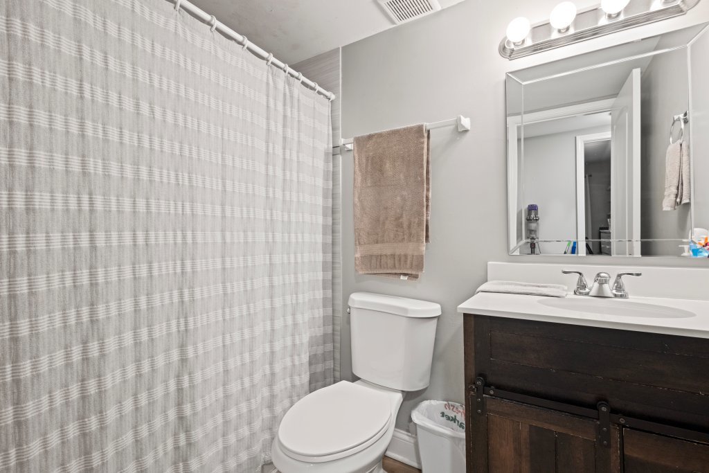 9830 Sayre Avenue, Unit 6 Chicago Ridge, IL 60415 - Photo 15 of 25 a bathroom with a toilet a sink a mirror and shower curtain