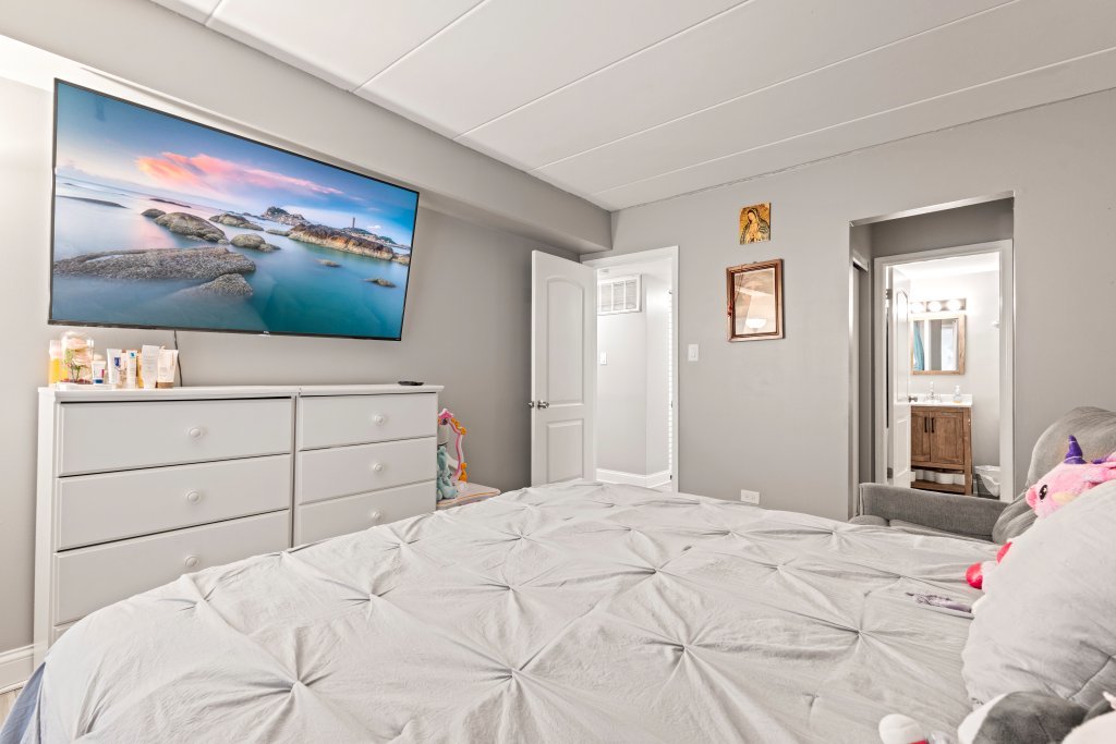 9830 Sayre Avenue, Unit 6 Chicago Ridge, IL 60415 - Photo 20 of 25 a bedroom with a bed and a flat screen tv
