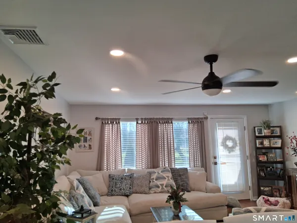 a living room with furniture plant and a window