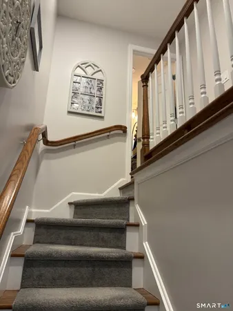 a view of a hallway with wooden floor and staircase