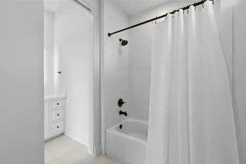a bathroom with a bathtub a shower and a shower