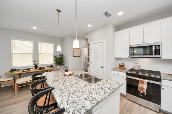 a kitchen with stainless steel appliances granite countertop refrigerator sink and cabinets