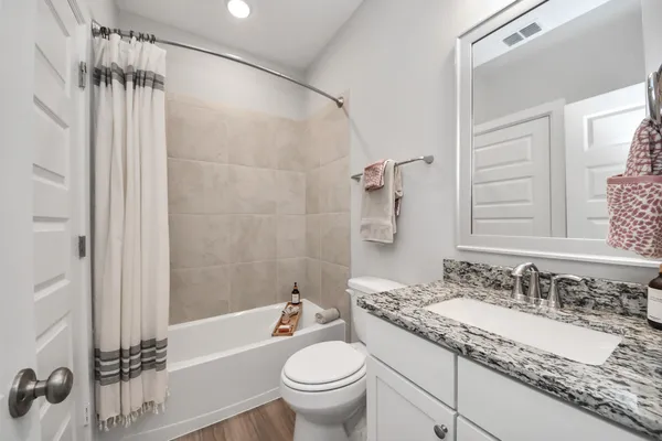 a bathroom with a granite countertop sink toilet and shower