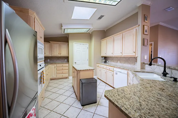 a kitchen with stainless steel appliances granite countertop a refrigerator sink and stove