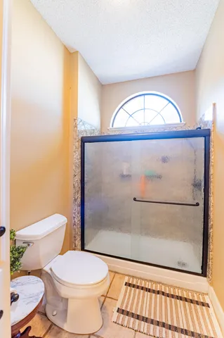 a bathroom with a toilet a a sink and a shower