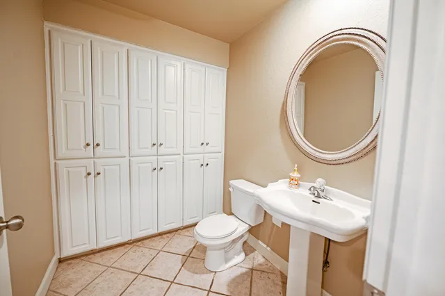a bathroom with a sink a toilet and a mirror
