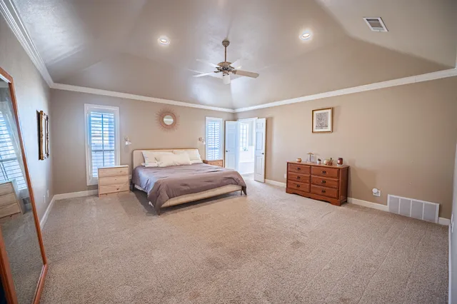 a spacious bedroom with a bed and a chandelier