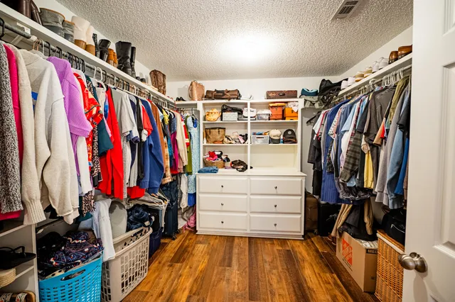 a view of walk in closet with clothes and shoes