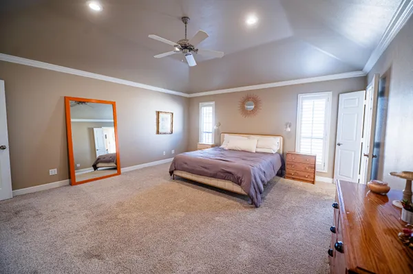 a spacious bedroom with a bed and a chandelier