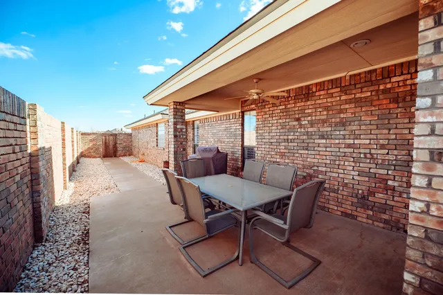 a view of a patio with a table and chairs and potted plants