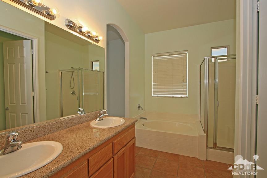 49478 Lewis Road Indio, CA 92201 - Photo 19 of 34 a bathroom with a granite countertop sink a mirror and a bathtub