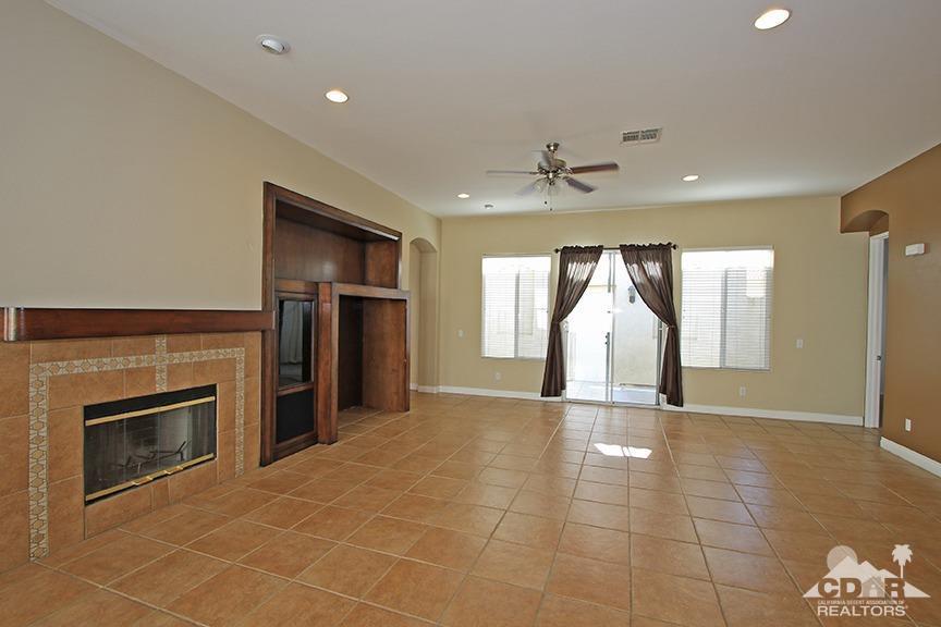 49478 Lewis Road Indio, CA 92201 - Photo 4 of 34 an empty room with a fireplace and stainless steel appliances