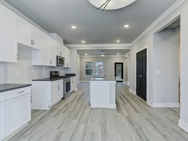 a kitchen with white cabinets and stainless steel appliances