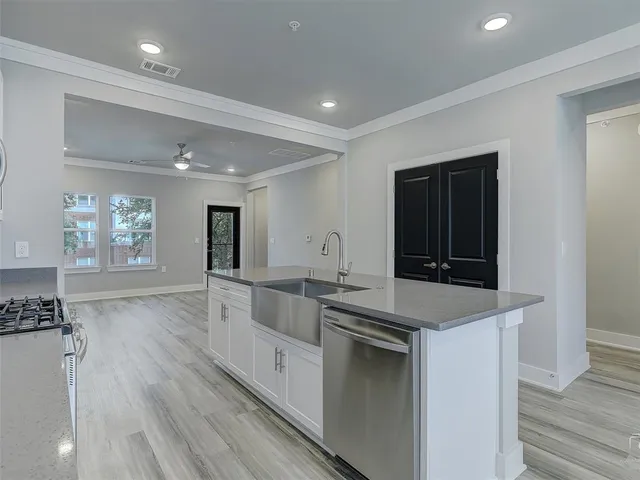 a large kitchen with stainless steel appliances granite countertop a lot of counter space and wooden floor