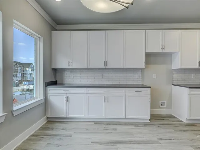 a kitchen with granite countertop white cabinets and sink