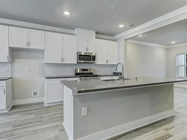 a kitchen with appliances a sink and cabinets