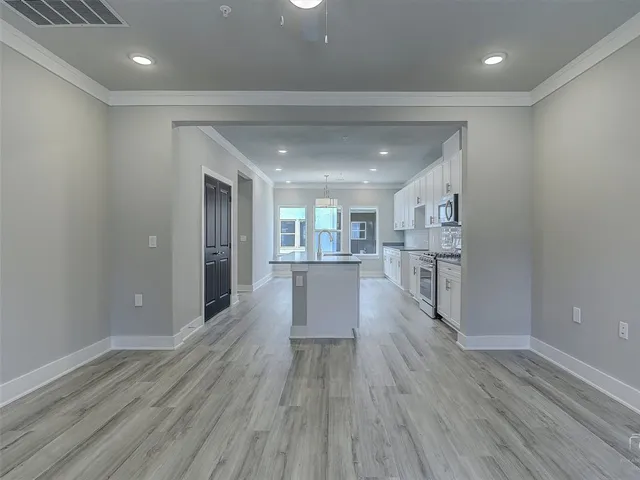 a view of a living room a wooden floor and kitchen