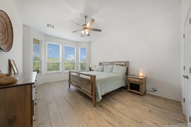 a bedroom with a bed wooden floor and window