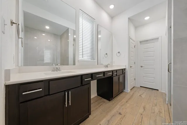 a large kitchen with stainless steel appliances granite countertop a sink and wooden cabinets
