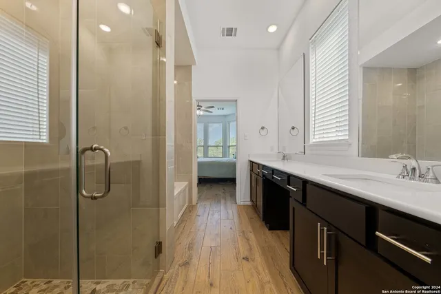 a bathroom with a double vanity sink a mirror and a shower