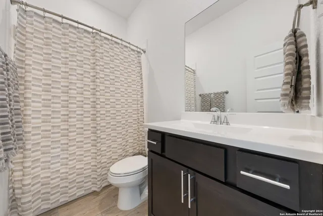 a bathroom with a toilet a sink and mirror