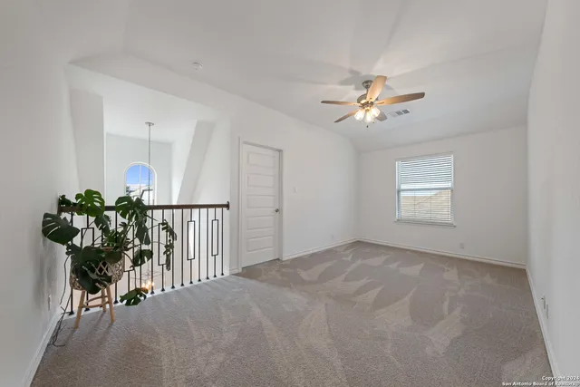 a view of a room with a ceiling fan and a rug