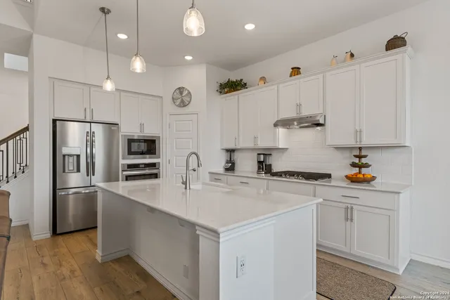 a kitchen with stainless steel appliances a refrigerator sink and cabinets