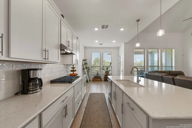 a large kitchen with stainless steel appliances granite countertop a lot of counter space and a sink