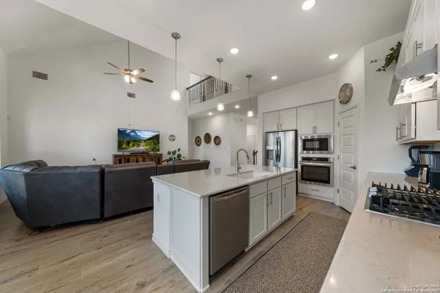 a kitchen with kitchen island stainless steel appliances a sink and a refrigerator