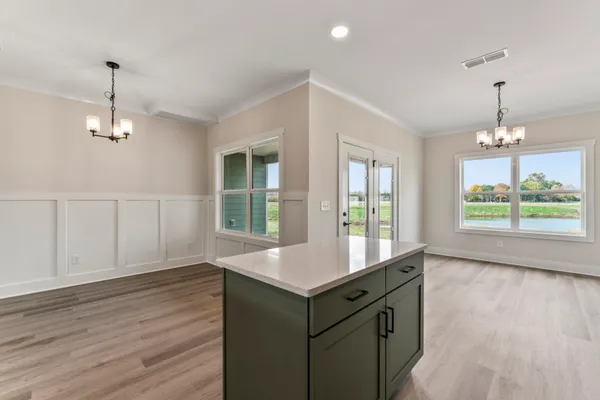a room with a sink chandelier and wooden floor
