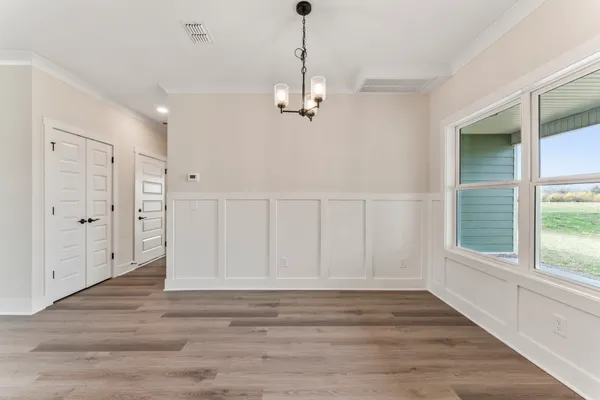 a view of empty room with wooden floor and window