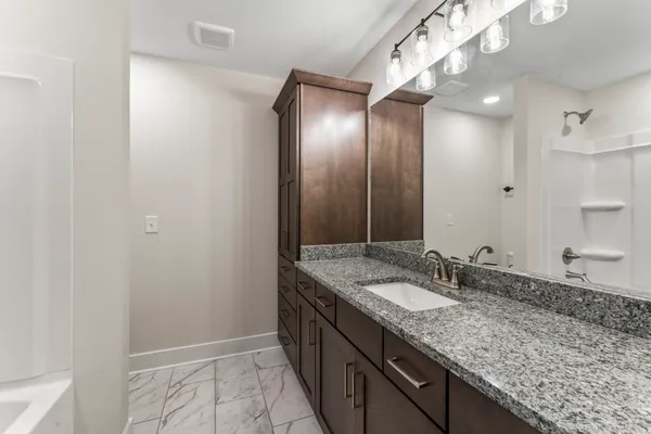 a bathroom with a granite countertop sink and a mirror