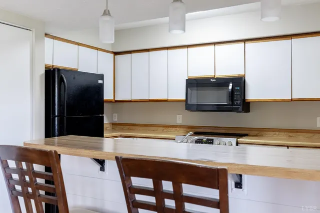 a kitchen with stainless steel appliances a table chairs and a refrigerator