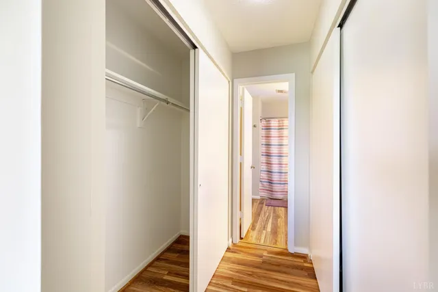 a view of a hallway with wooden floor and entryway