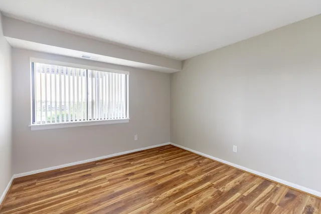 a view of a room with wooden floor and windows