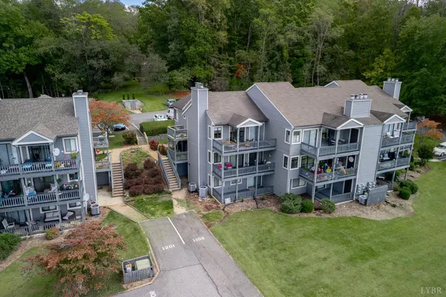 a aerial view of a house next to a big yard and large trees