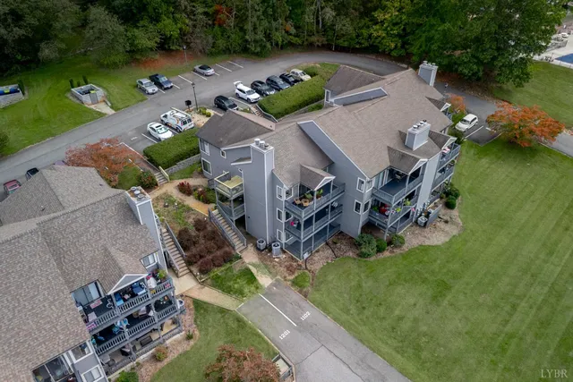 an aerial view of a house with a garden and lake view