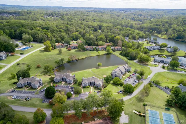 an aerial view of lake residential house with swimming pool and mountains