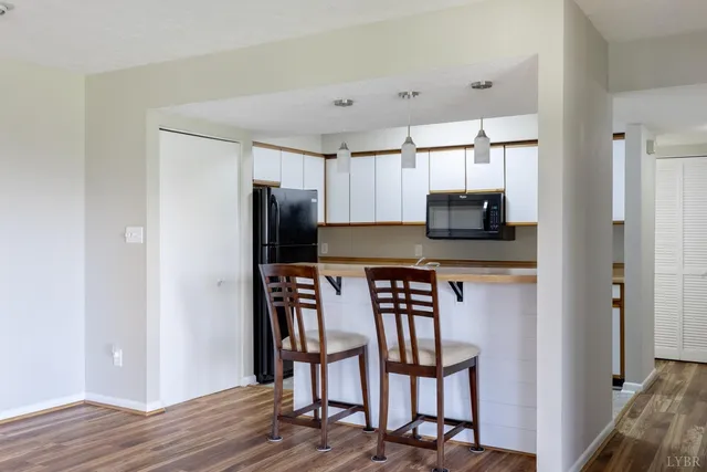 a kitchen with a table chairs refrigerator and microwave