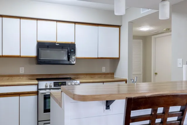 a kitchen with a sink a microwave a stove and cabinets