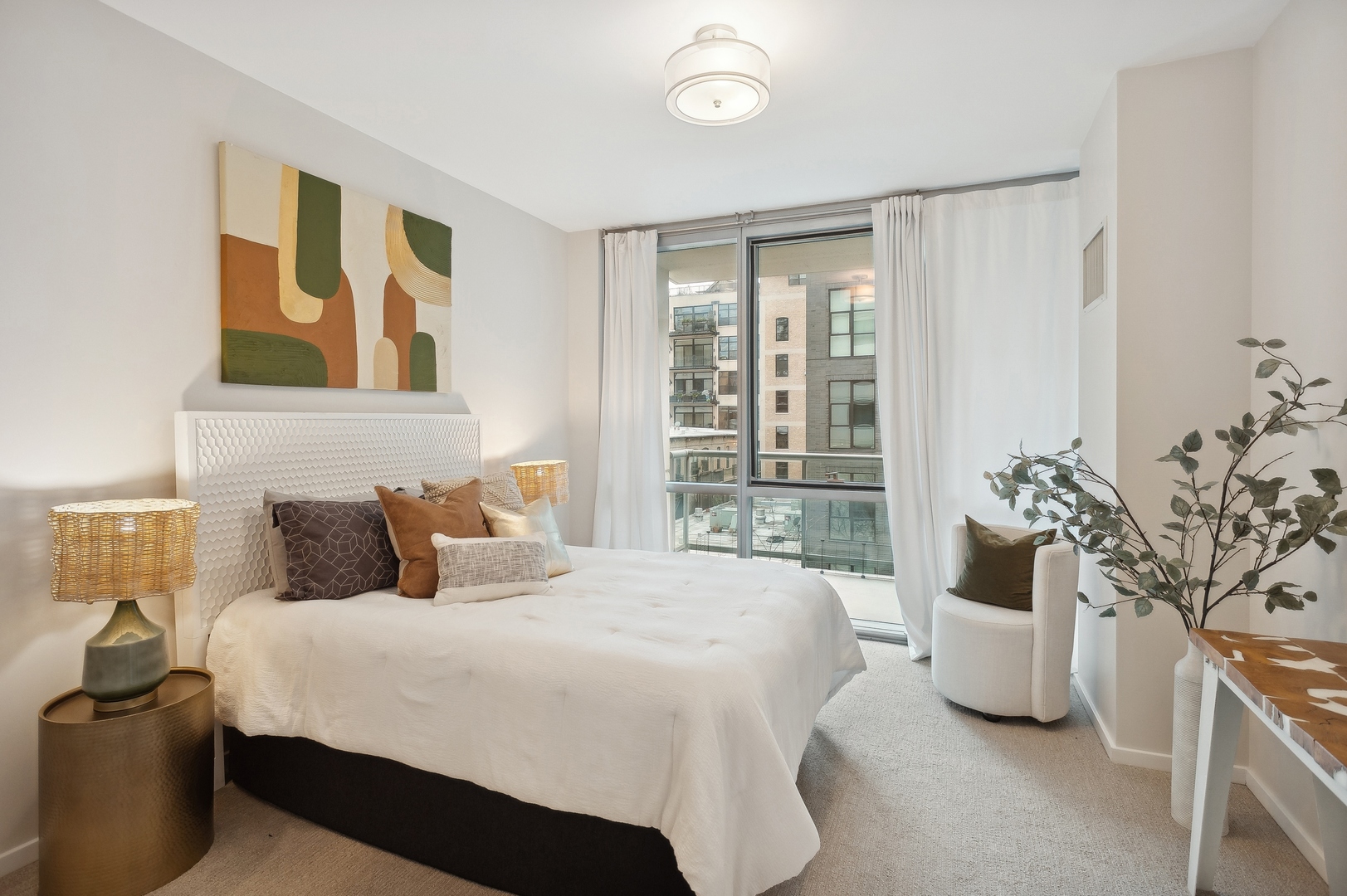 125 South Green Street, Unit 409A Chicago, IL 60607 - Photo 11 of 18 a bedroom with a large bed and a potted plant