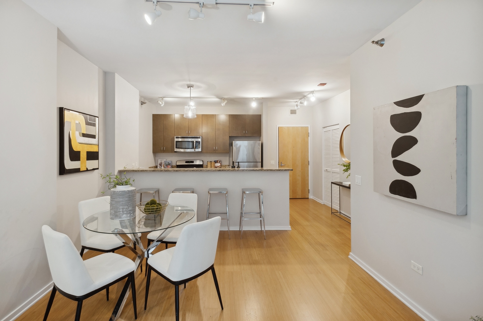 125 South Green Street, Unit 409A Chicago, IL 60607 - Photo 6 of 18 a kitchen with stainless steel appliances kitchen island granite countertop a table and chairs