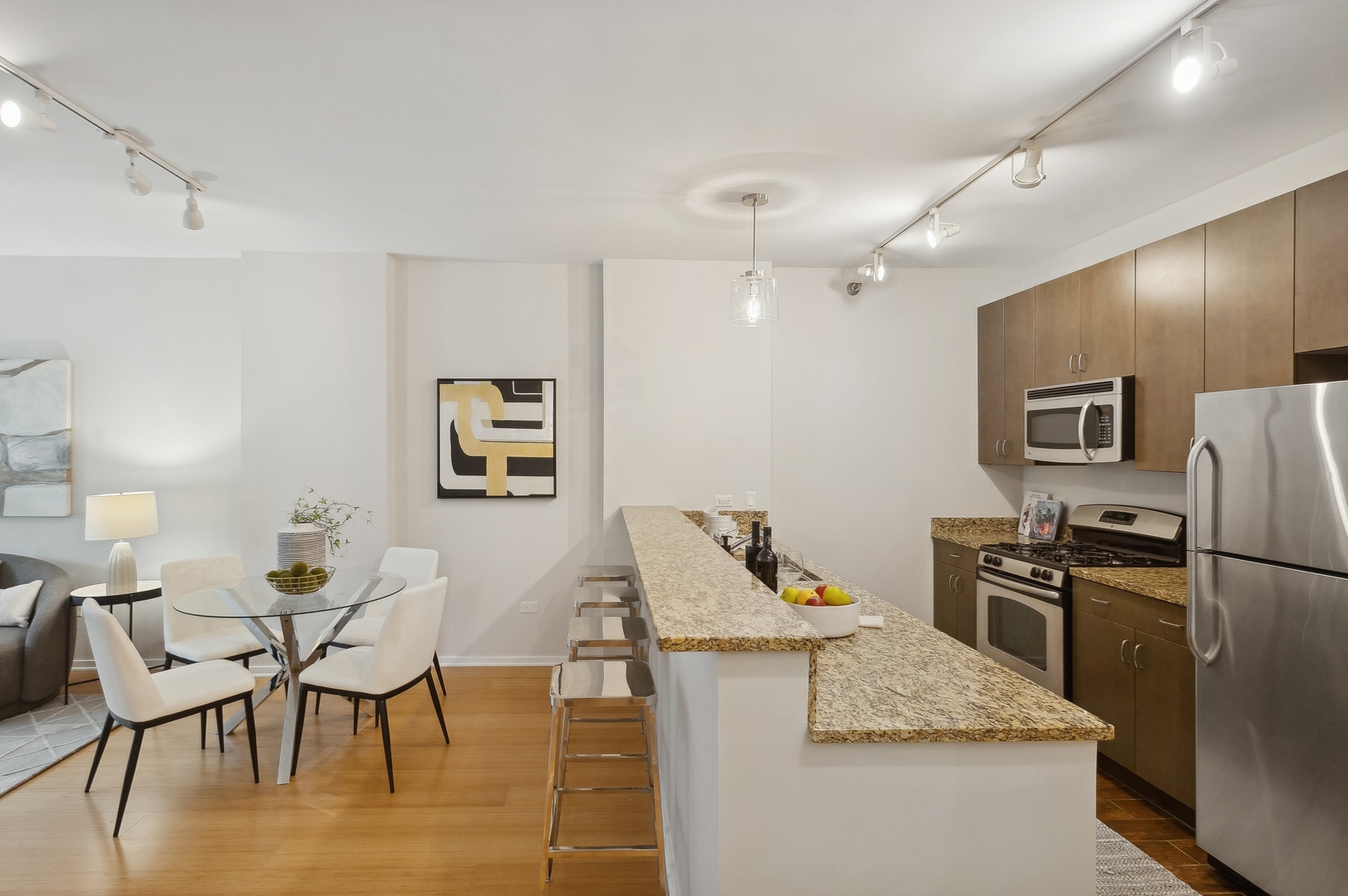 125 South Green Street, Unit 409A Chicago, IL 60607 - Photo 7 of 18 a living room with stainless steel appliances kitchen island granite countertop furniture and a refrigerator